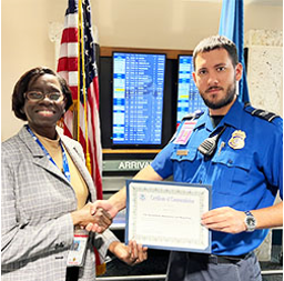 Palm Beach International Airport TSA Manager Roniecia Hilliard presents TSA Officer Ryan Perreault with a Certificate of Commendation.  (Photo by Joseph Aiuto)