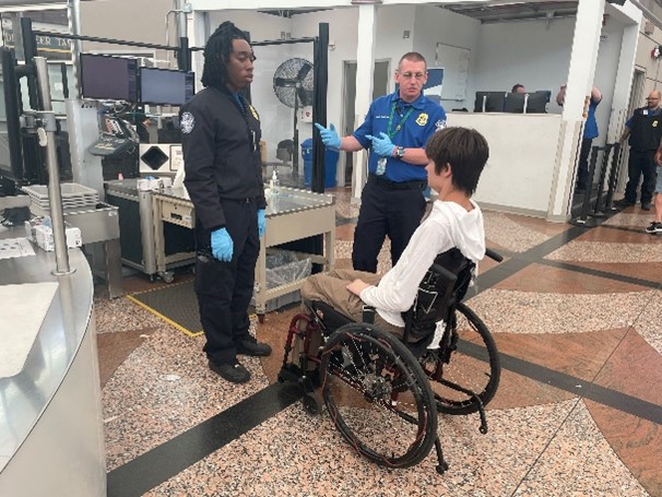 TSO Ebenezer Doi Jr. (left) and LTSO Jason Blair (right) explain the procedure to a DAD passenger. (Photo by DEN)