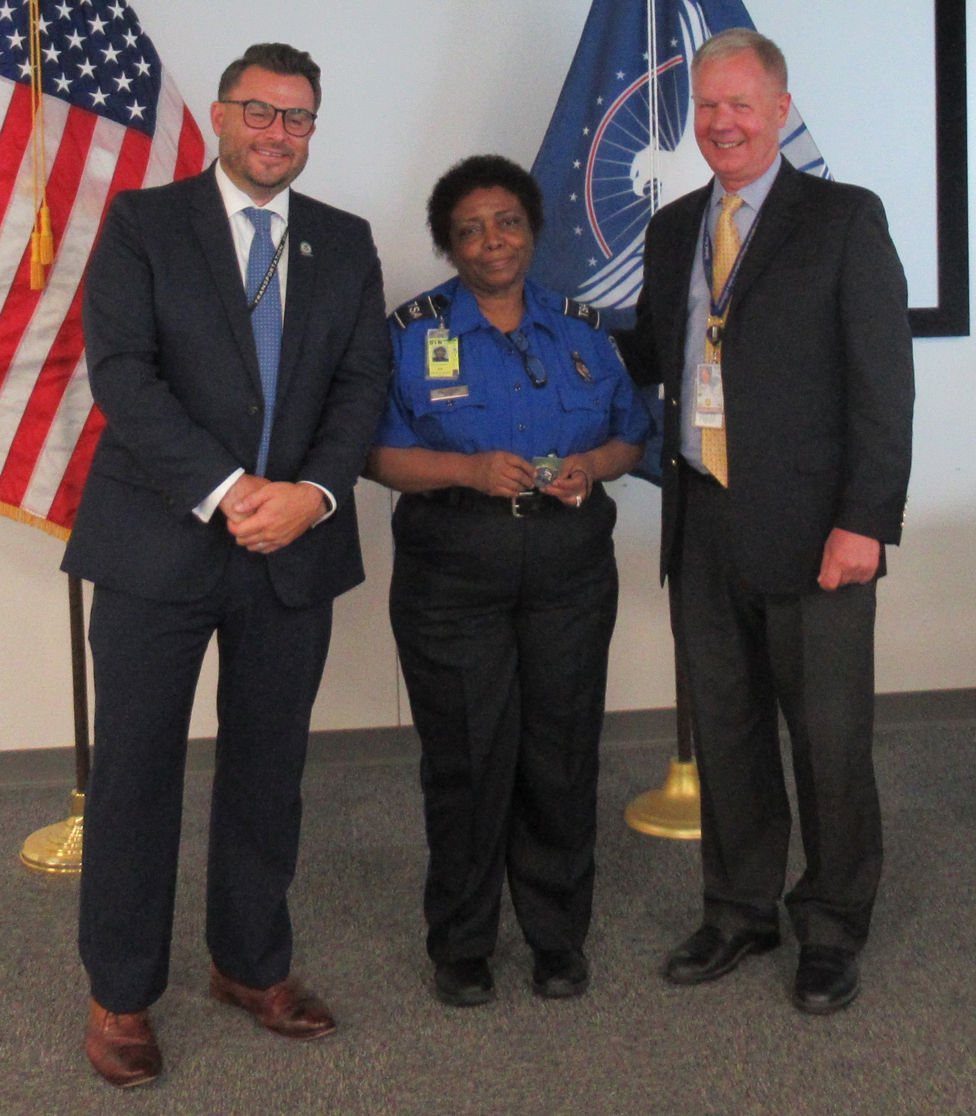 TSA officer Alyce McCampbell was one of several TSA employees at Syracuse Hancock International Airport who was recognized for 20 years of service to TSA. She was awarded a coin from TSA Federal Security Director Bart R. Johnson (right) and TSA Deputy Federal Security Director Brian Bushnell. (TSA photo)