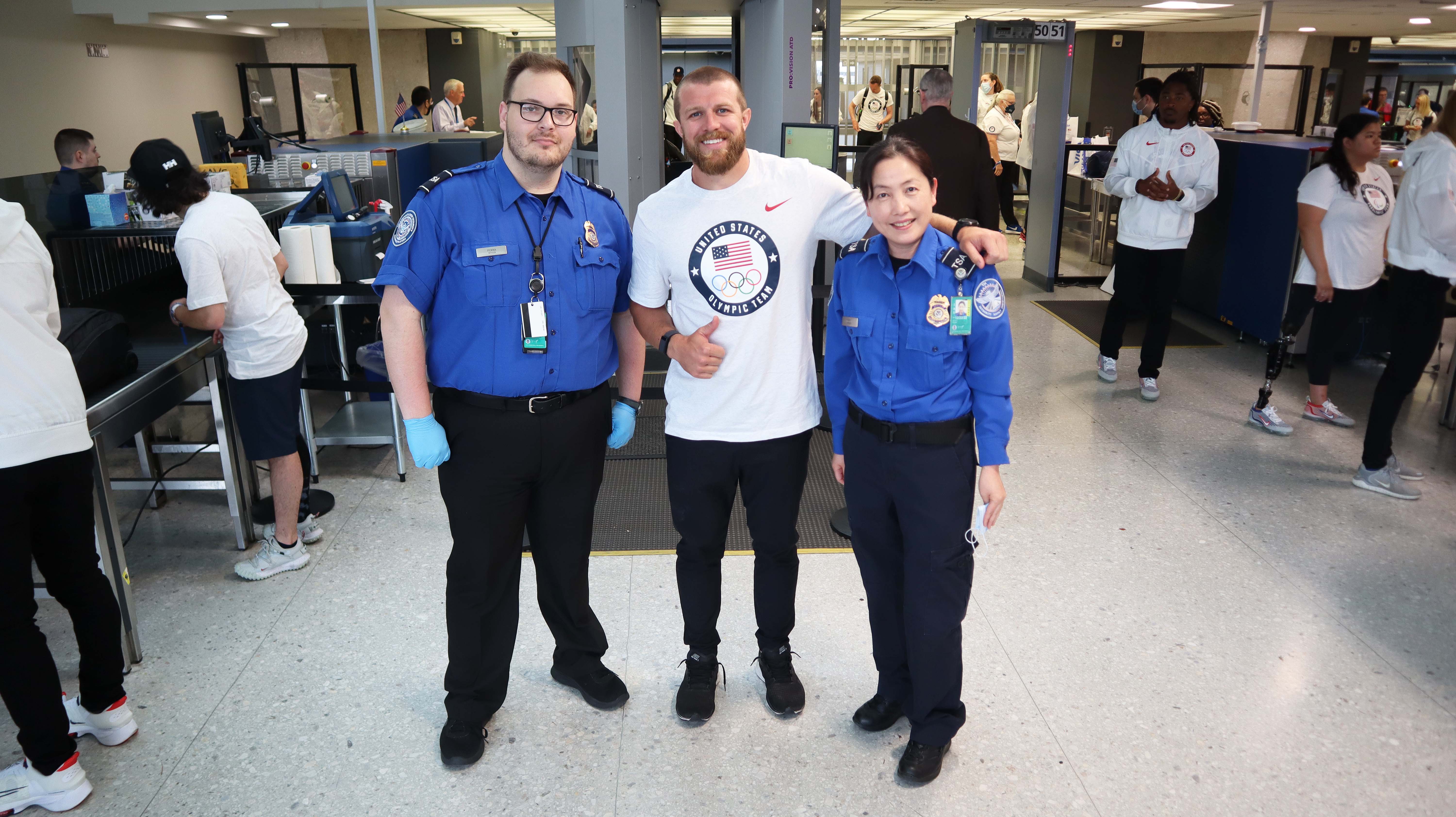 TSA Officers Tristan Penna (left) and Sena Park take a quick break at the checkpoint for a snapshot with one of the U.S. Olympians who attended a White House ceremony and flew out of Washington Dulles International Airport. (Photo by Eric Beane)