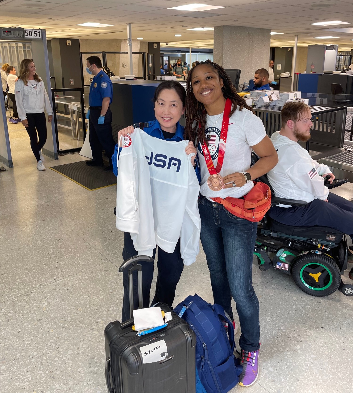 IAD TSA Officer Sena Park poses with 2022 Winter Olympian Sylvia Hoffman who won a bronze medal in bobsled. Hoffman gave Park her USA team jacket during the brief visit. (Photo by Eric Beane)