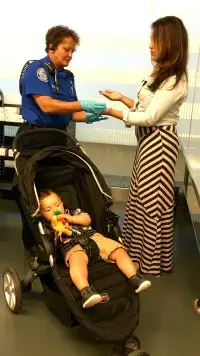 A woman traveling with her toddler has her hands swabbed for any traces of explosives. (TSA photo)