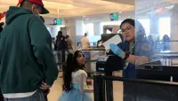 A TSA officer welcomes a family to the PHX checkpoint. (TSA PHX)