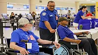 Supervisory TSA Officer Jeffrey Rodriguez helps veteran heroes with special screening before their flight at Puerto Rico’s Luis Muñoz Marin International Airport. (Carlos Z. Cardona)