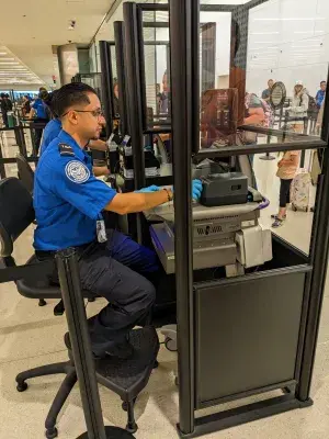 TSA Officer Ramon Caballero inspects documents at a TSA checkpoint. (Photo courtesy of Ramon Caballero)