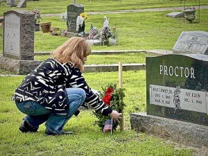 Heather Proctor places a U.S. flag on a veteran’s grave. (Photo courtesy of Heather Proctor)