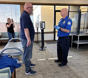 Lead TSA Officer William Wolaver prepares to pat down a chaperone. (Alan Johnson photo)