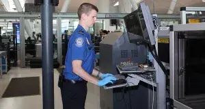Supervisory TSA Officer Richard White works an X-ray machine at one of the TSA checkpoints at John F. Kennedy International Airport. (Photo by Christopher Kirchein)